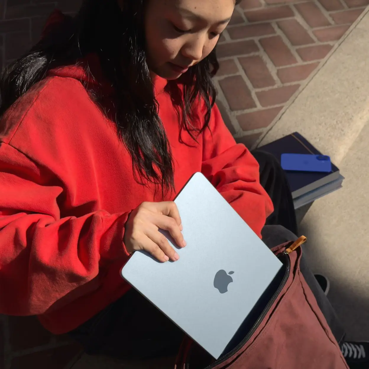 A person enrolling a phone using a MacBook, demonstrating device management.