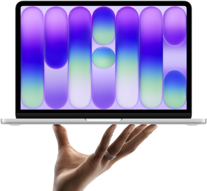 MacBook Neo in silver color, balanced on fingertips of open hand, screen displaying colorful abstract pattern