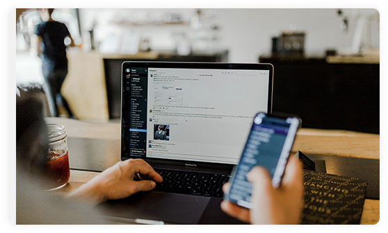 A modern desk setup with an iMac, MacBook, iPad, and iPhone.
