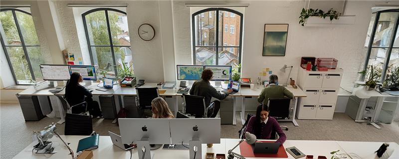 A person in a suit holding a glowing green recycle symbol.