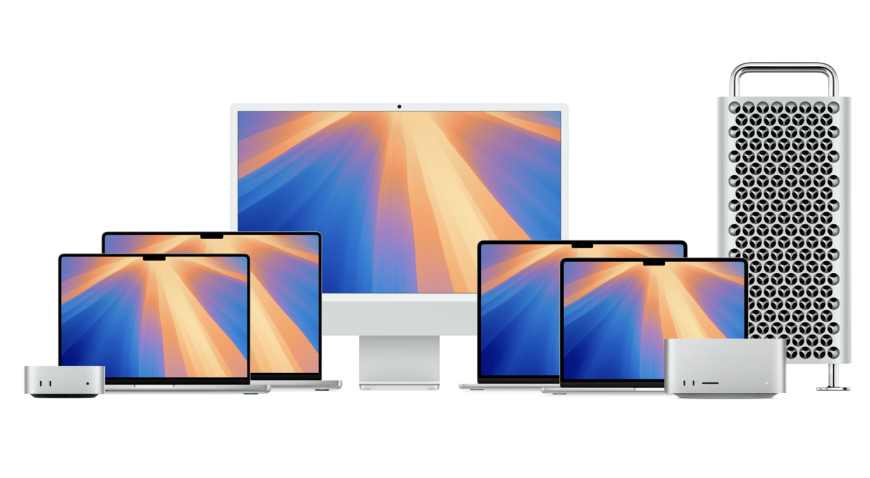 A modern desk setup with an iMac, MacBook, iPad, and iPhone.